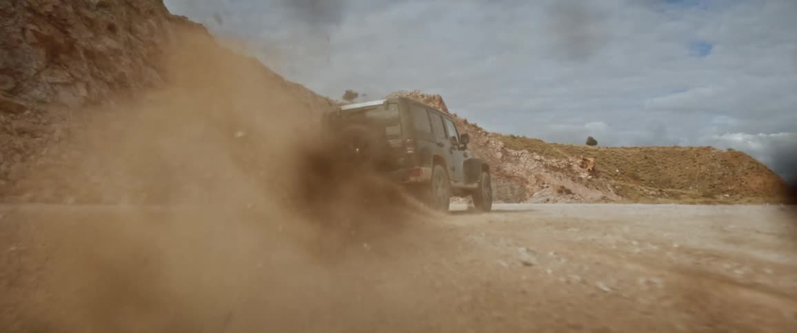 Black jeep drifts to the right in the field