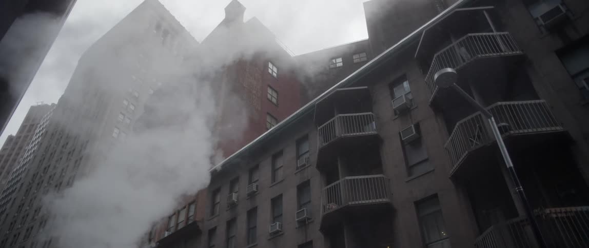 Smoke slowly rises near these buildings