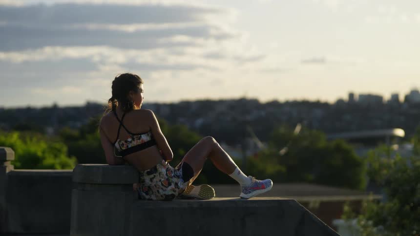 A woman is sitting on a ledge during the springtime