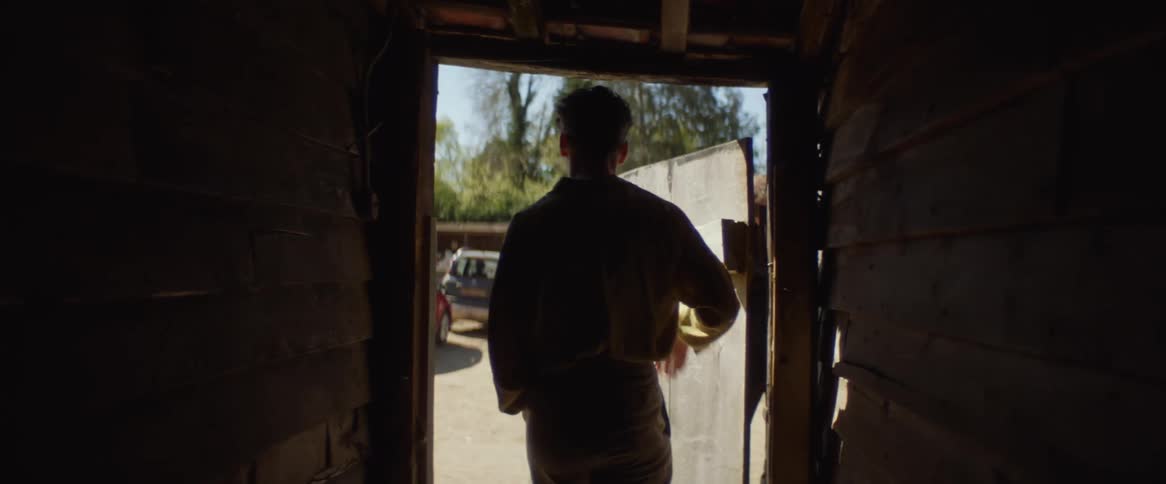 A man walks down the hall to go outside