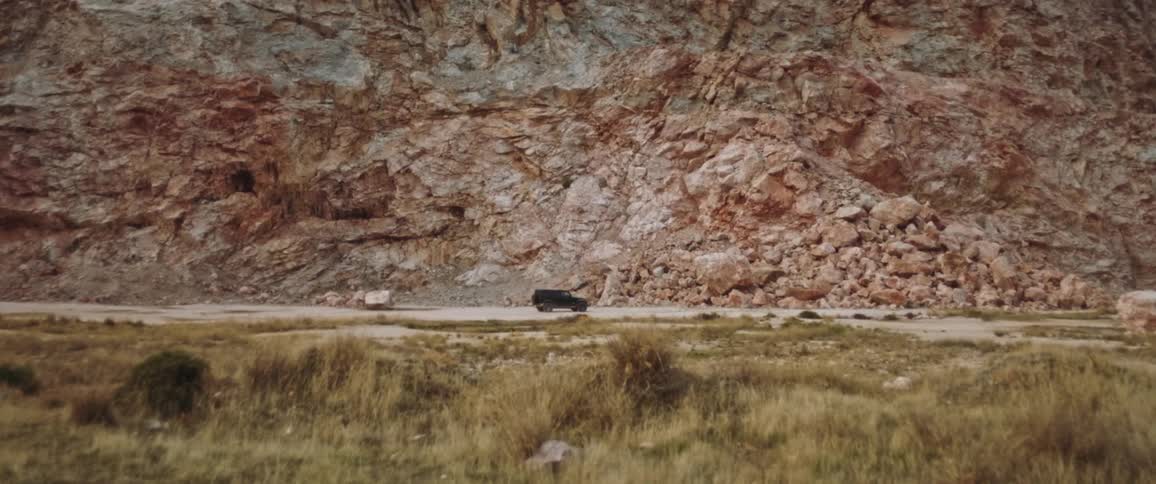 Jeep driving across dirt path through the canyon