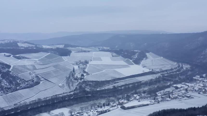Aerial view of snowy mountain slope and buildings