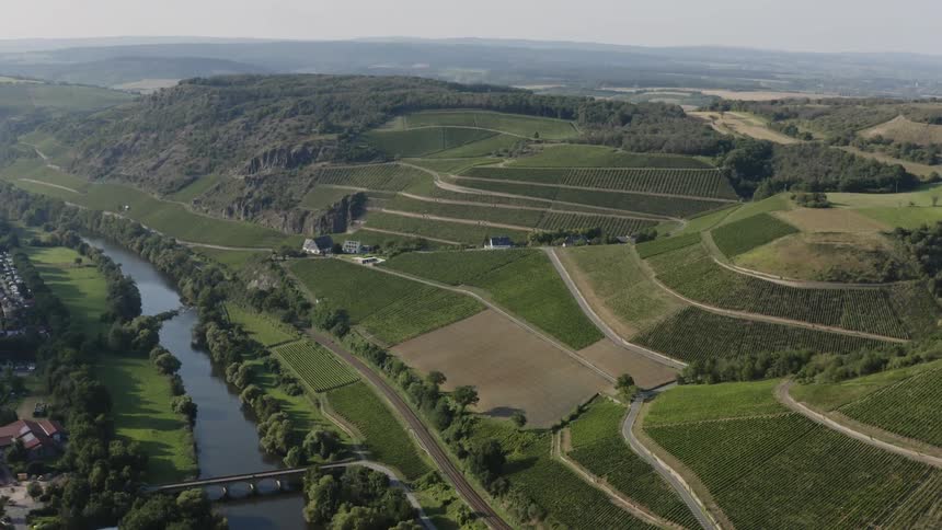 An aerial view of a hillside with green fields and roads throughout