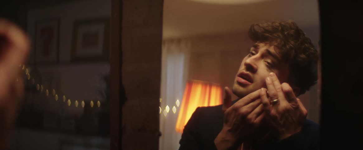 A man massages his face in the mirror