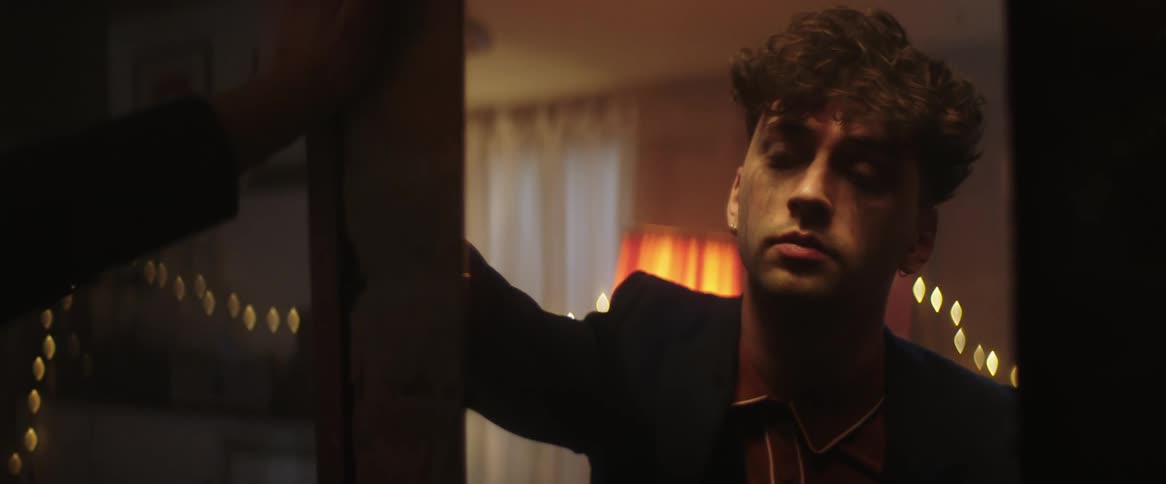 Sad man in black blazer jacket looks out the window