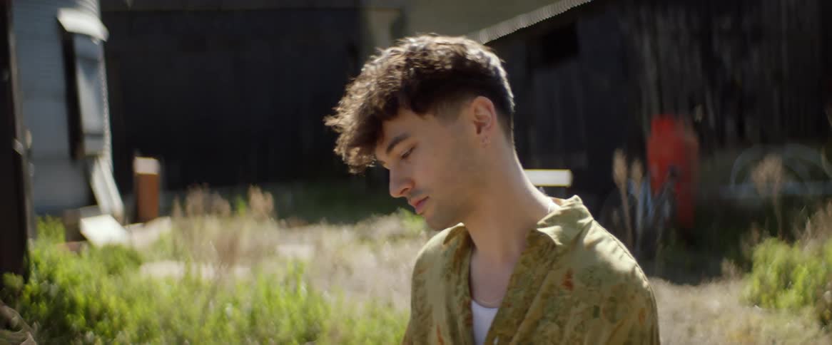 A male playing piano nodding his head looking sad