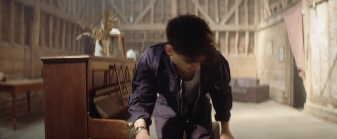 A teenage boy sits down and plays the piano