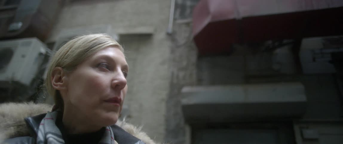 Older blonde woman looking around in a dingy area