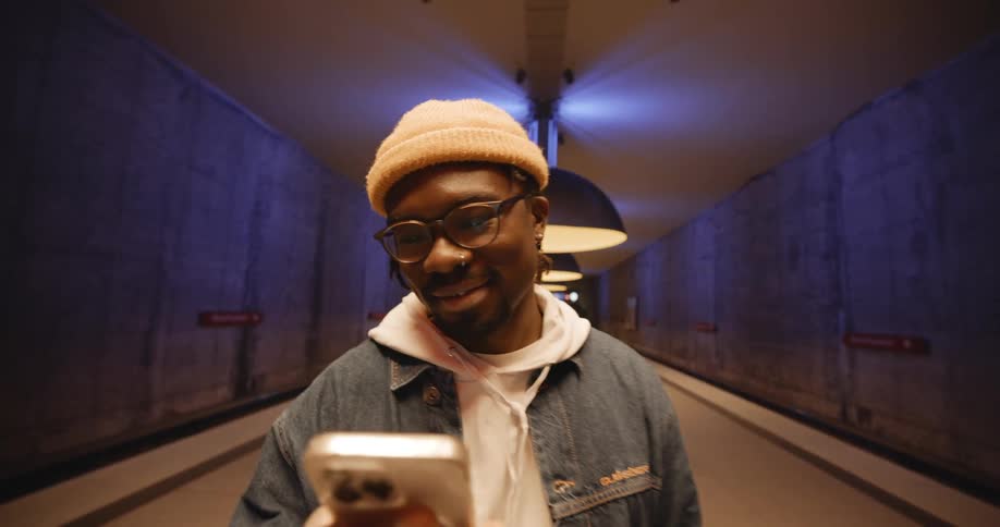 A man is smiling and standing in a hallway