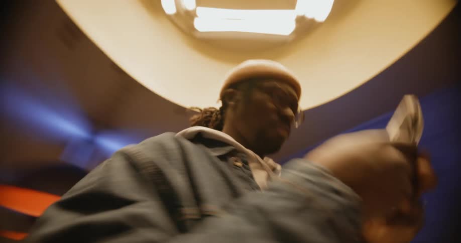 A man holds his cell phone and spins in circles