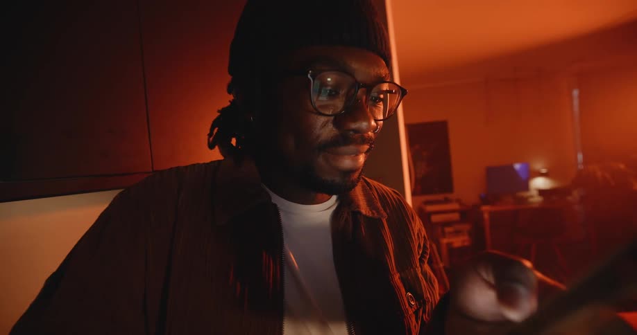A man scrolls through his phone while standing in his living room