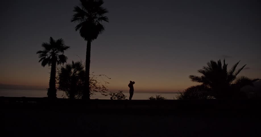 A woman stands on the shore and takes photos
