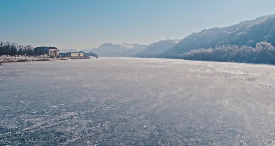 Buildings sit across frozen water from mountains