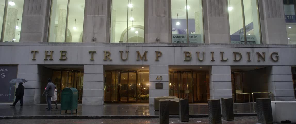People walk past the trump building