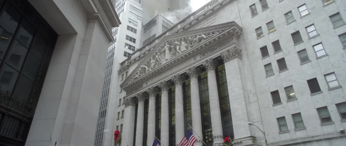 A city corner has flags on the front of a building ahead