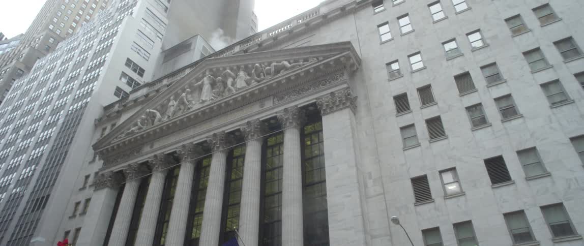 American flags fly outside a pillared city building