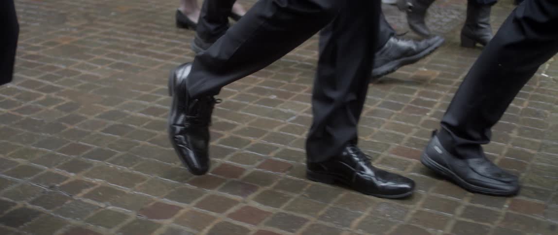 People walk on the sidewalk on a rainy day