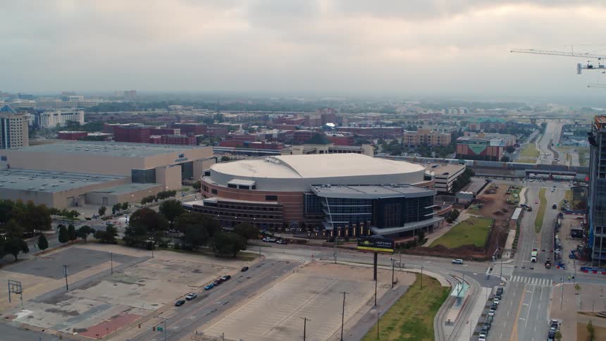 An aerial of a stadium at an intersection with a metropolis city in the back