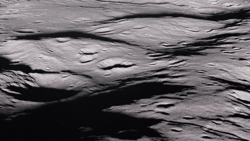 The surface of the planet Mercury shows craters in shadow