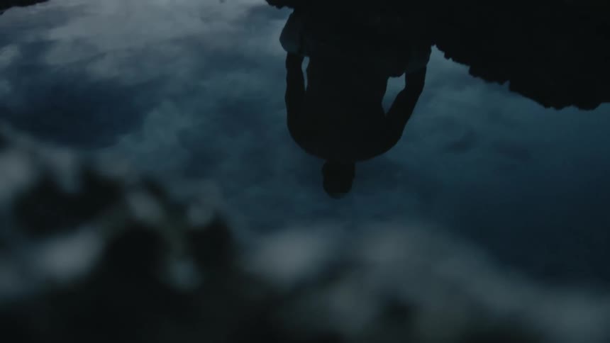 Man is silhouetted against cloudy sky in reflection