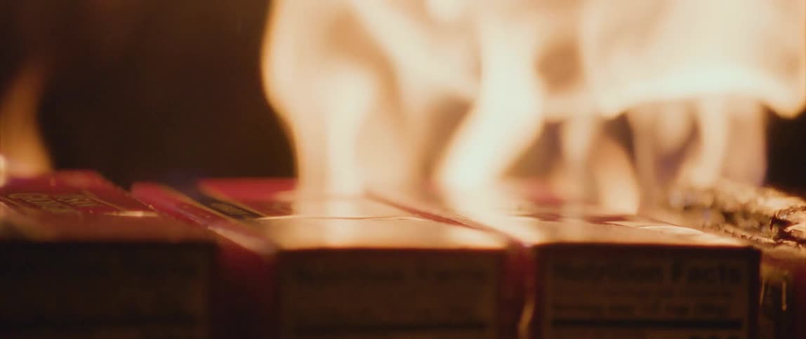 Flames waver and move as they burn boxes in the darkness