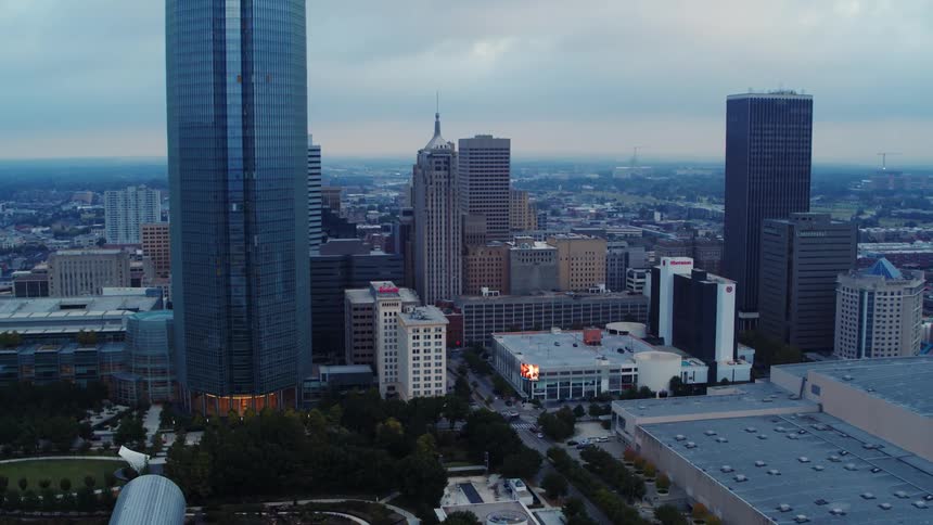 An aerial of a city with tall buildings and trees aligning the streets