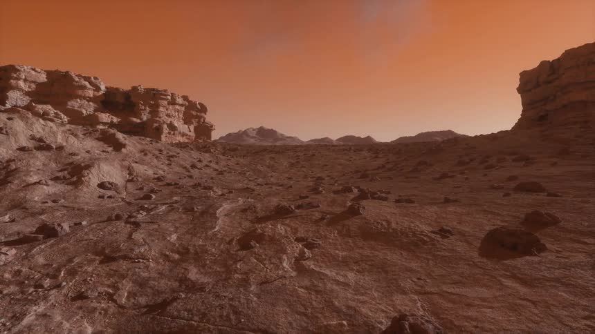 Rough and bumpy ground fills the land below a canyon on Mars