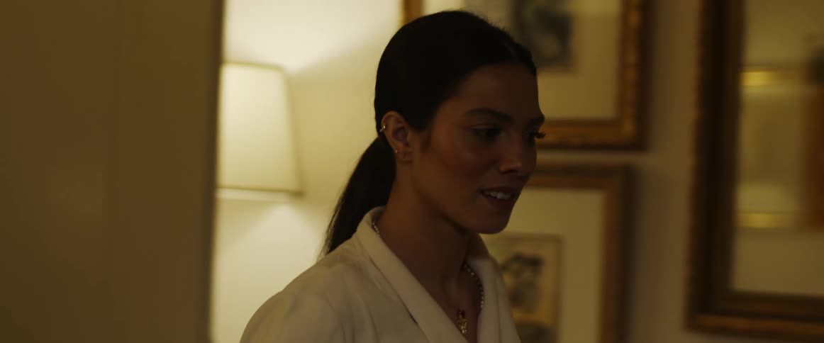 A woman walking through a house smiling and looking around and then smelling yellow flowers