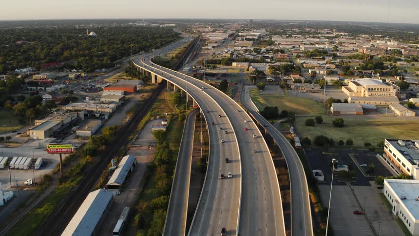 Cars driving on a freeway past businesses
