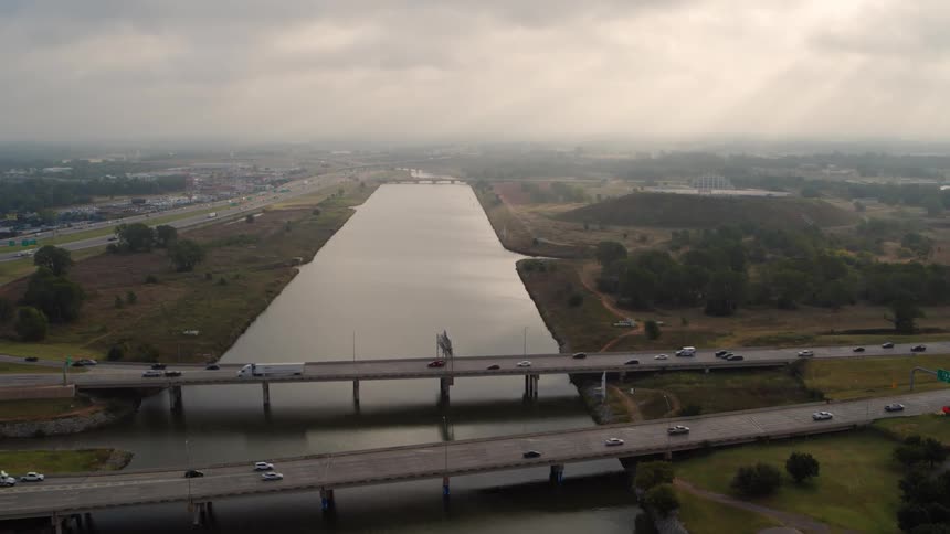An aerial of a bridge with traffic crossing it over a waterway