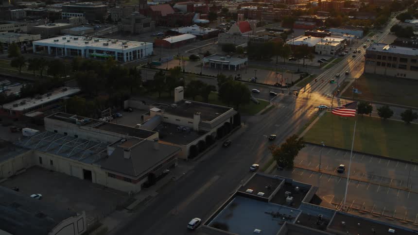 An aerial view of a roadway with cars and a metropolis city and sunset