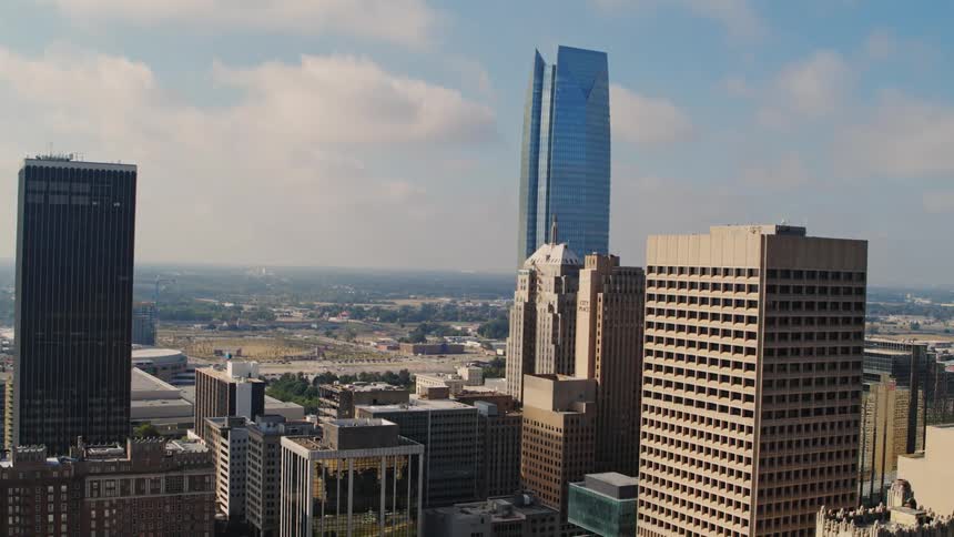 Skyscrapers tower over surroundings as city stretches to misty horizon on a cloudy day