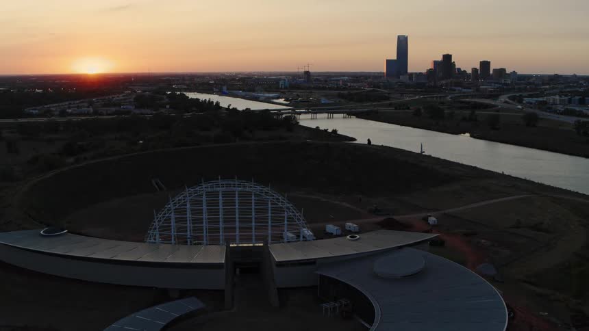 An outdoor entertainment stadium sits across the river from downtown