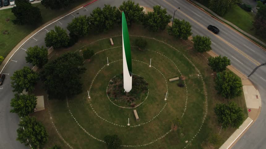 Traffic moves on the street as the beacon of hope stands tall in stiles park