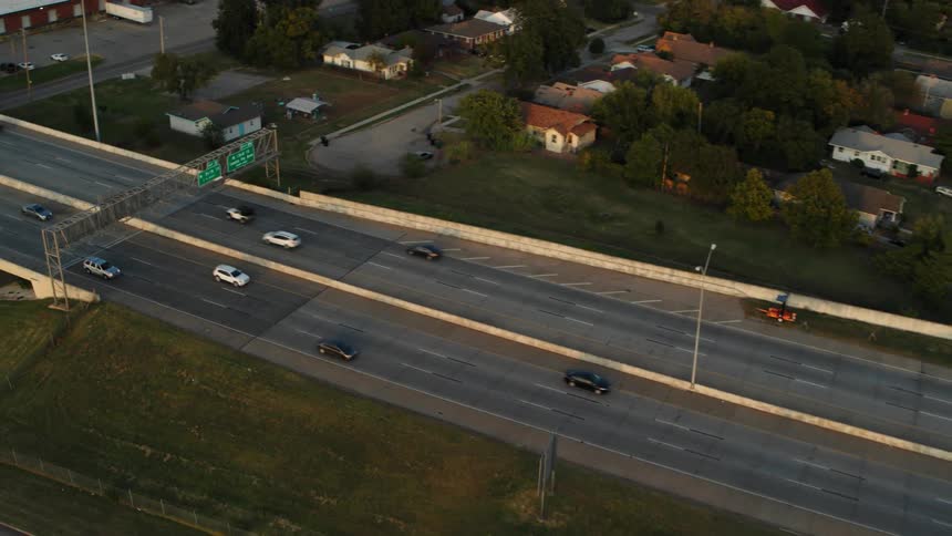 An aerial view of a highway and then backing out to see the city in the distance