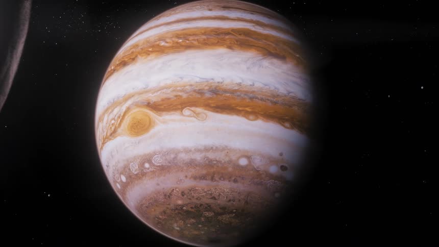Planet Jupiter is revealed behind one of its moons