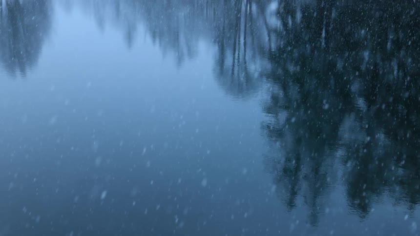 Snow is coming down on the lake in winter