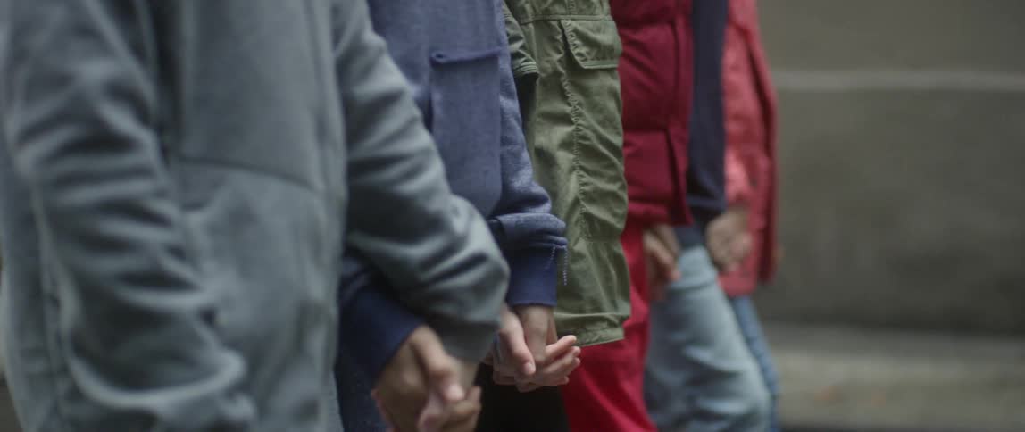 People are holding hands together walking