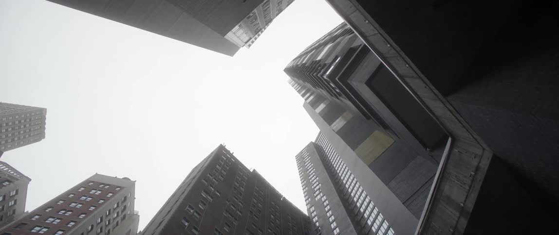 The sky is full of clouds above these tall buildings