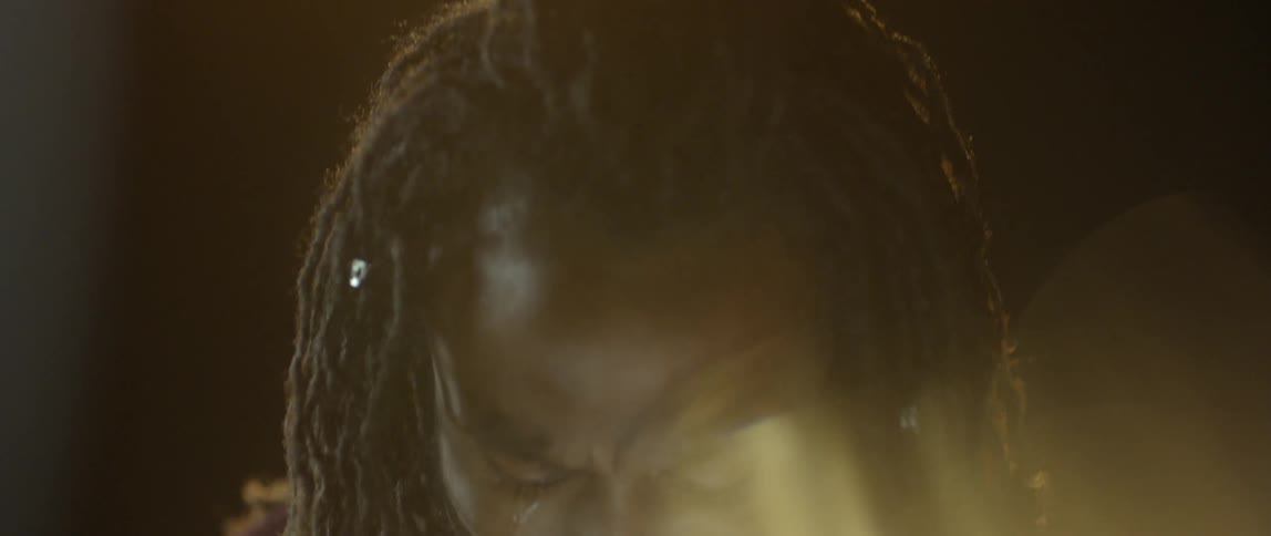 A man with long hair is crying