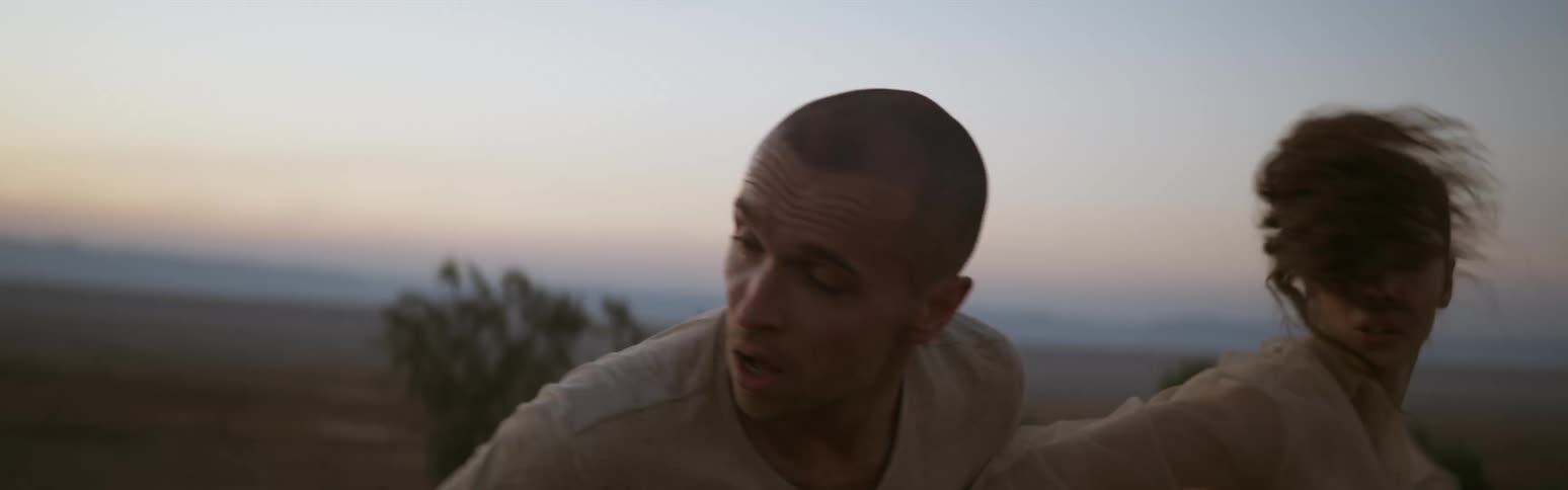 Young couple running after each other and struggling in the desert at evening
