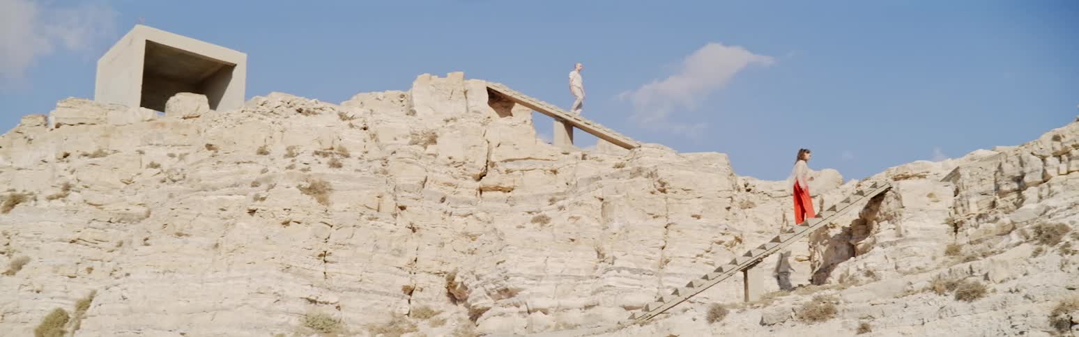 Two people climb on steps on the mountain