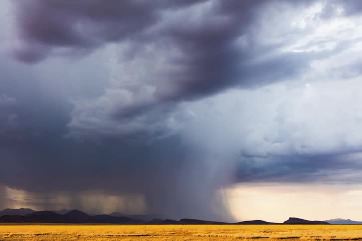 Time lapse of a monsoon strong downburst moving away over desert mountains