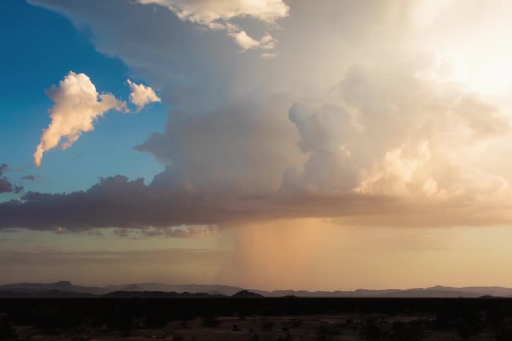 An isolated monsoon thunderstorm and lightning over the desert mountains