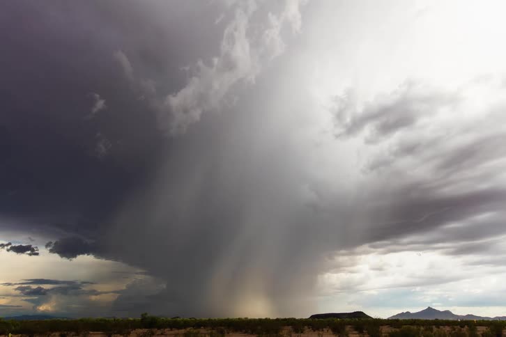 A monsoon downburst storm forming over the desert mid day