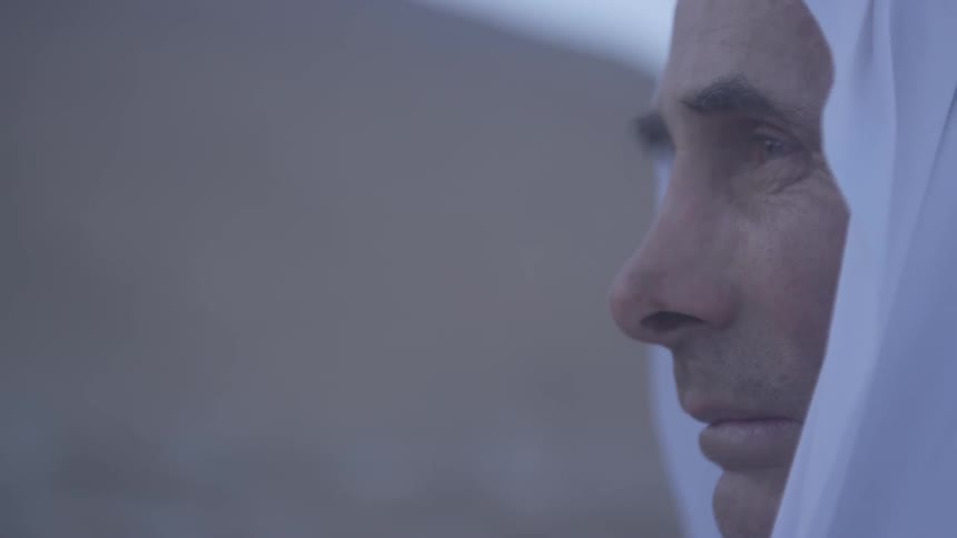 Profile of a man with a white cloth draped over his head