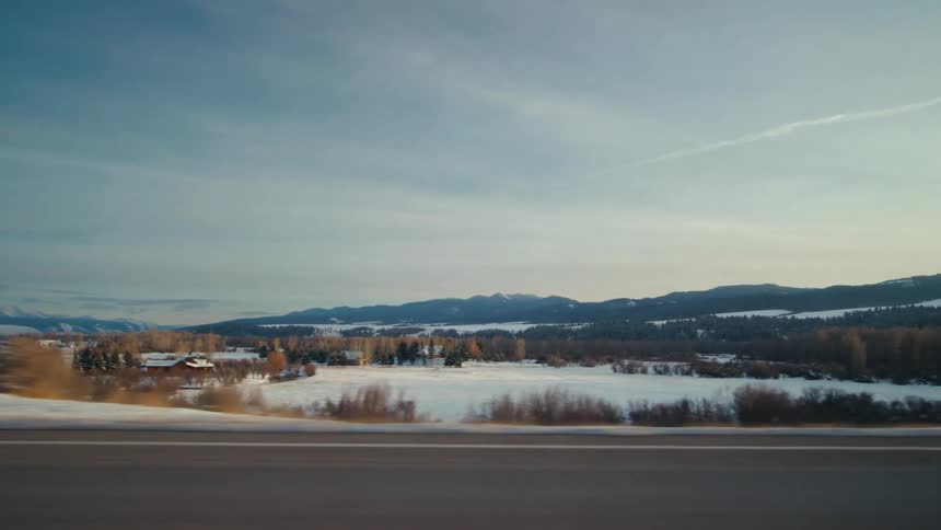 A road through a snowy countryside during the day