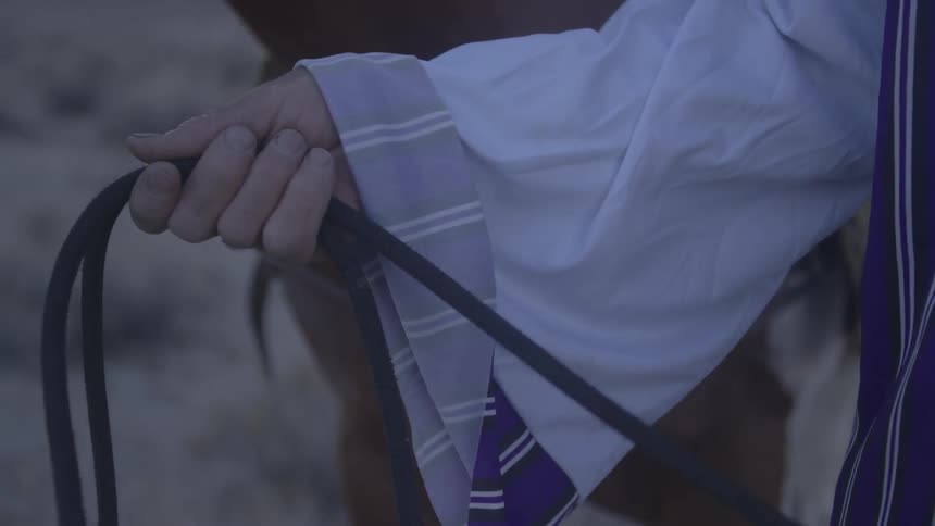 A person wraps a rope around their hand