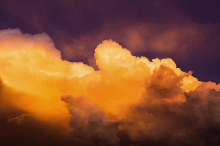 Golden sunset thunderstorms float in the sky