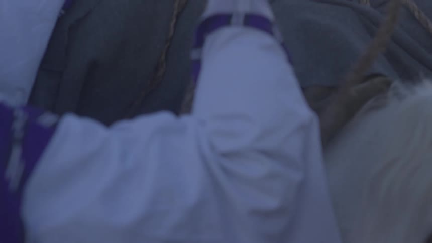 A person is tying a bag to a horse